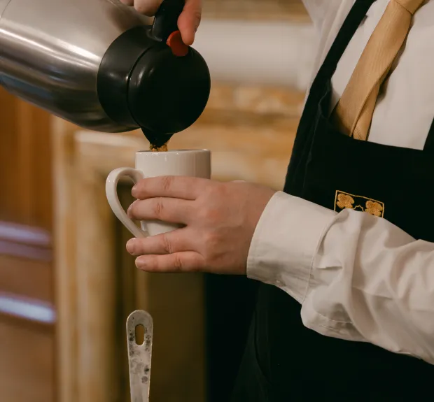 a server pouring a coffee cup at a breakfast event